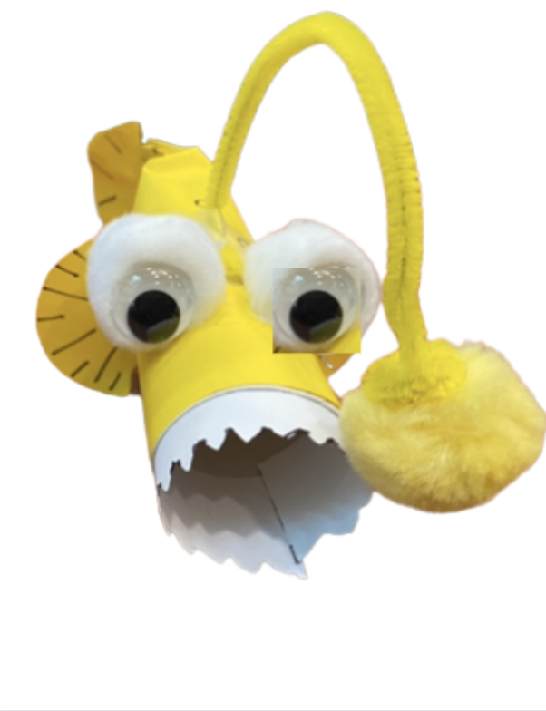 Yellow anglerfish craft made of paper tube, googly eyes, a pom pom.