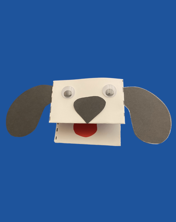 White dog with googly eyes, black nose and ears, and red tongue on a blue background