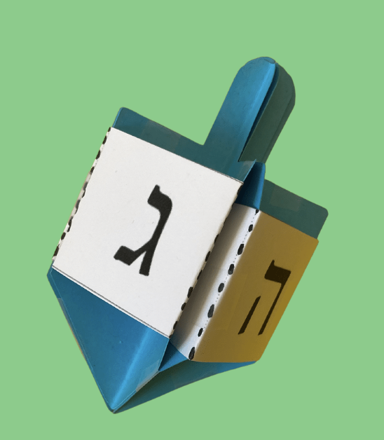Blue and white paper dreidel on a light green background