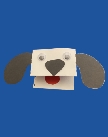 White dog with googly eyes, black nose and ears, and red tongue on a blue background