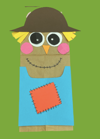 Scarecrow paper bag puppet on green background